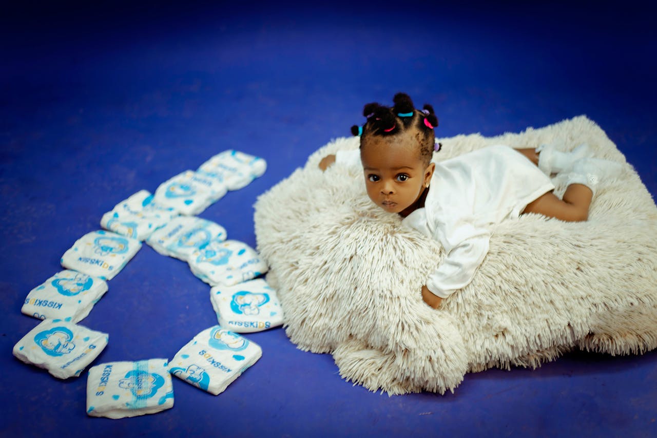 The Art of Drawing Readers In: Your attractive post title goes here Cute baby lying on a soft rug with diapers arranged in a heart shape.