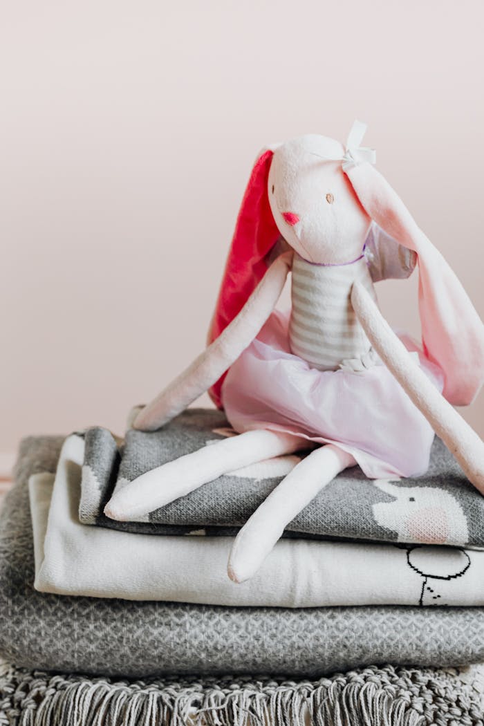 Crafting Captivating Headlines: Your awesome post title goes here Adorable stuffed bunny toy sitting atop neatly folded blankets, creating a cozy atmosphere.