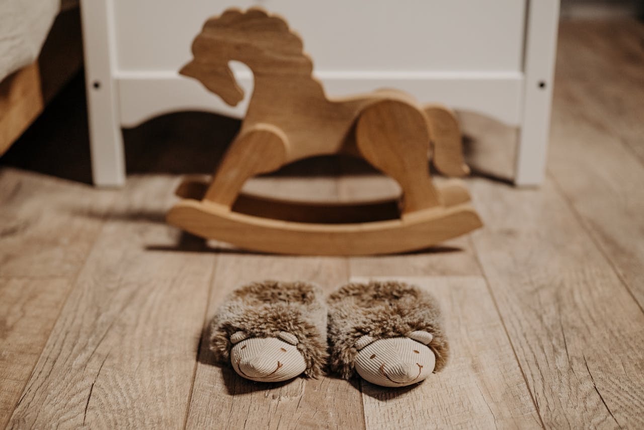 Mastering the First Impression: Your intriguing post title goes here Warm, fluffy slippers on wooden floor in nursery beside a wooden rocking horse.